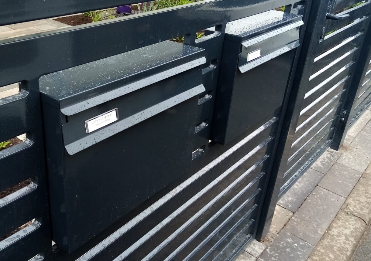 moderner Briefkasten am Zaun