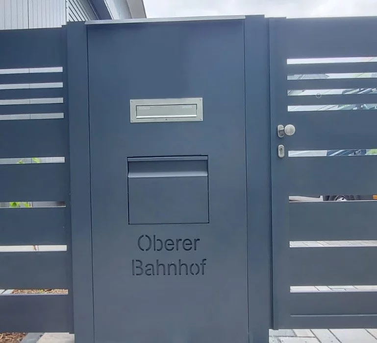 Metallsäule mit Briefkasten und Paketbox